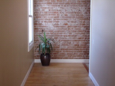 Lofts at the Drew - Exposed Brick Wall In Interior Corridor